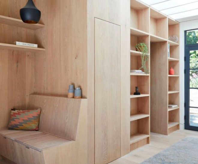 Các khu vực chức năng được bố trí đơn giản. Từ cửa trước vào nhà là hệ thống kệ đứng kết nối từ sàn lên đến trần, vừa tiết kiệm diện tích vừa tăng thêm không gian lưu trữ.