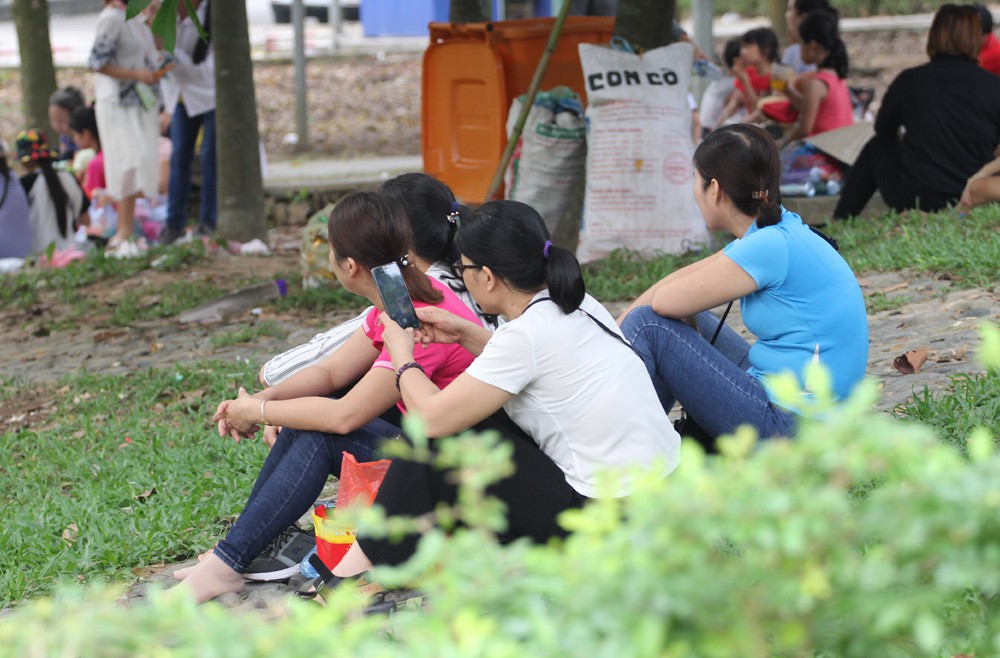 Hoặc những người phụ nữ tranh thủ lướt Facebook dưới tán cây.