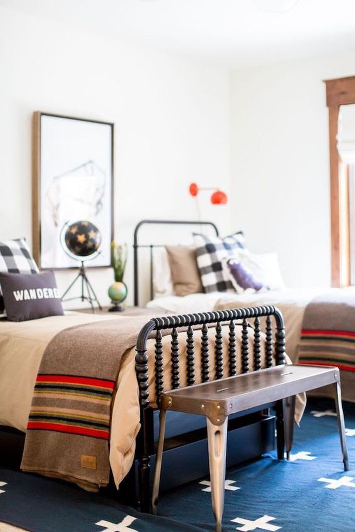 
Một phòng ngủ đầy màu sắc với hai giường, hàng dệt khác nhau và đèn, phụ kiện hấp dẫn.
