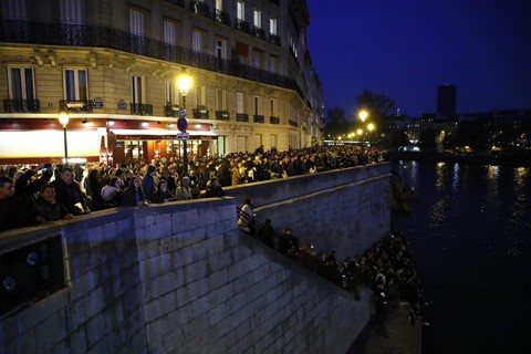 Người Paris cũng như du khách đã tập trung dọc hai bên bờ sông Seine để cầu nguyện trong lúc vụ cháy đang xảy ra. Ảnh: AP.