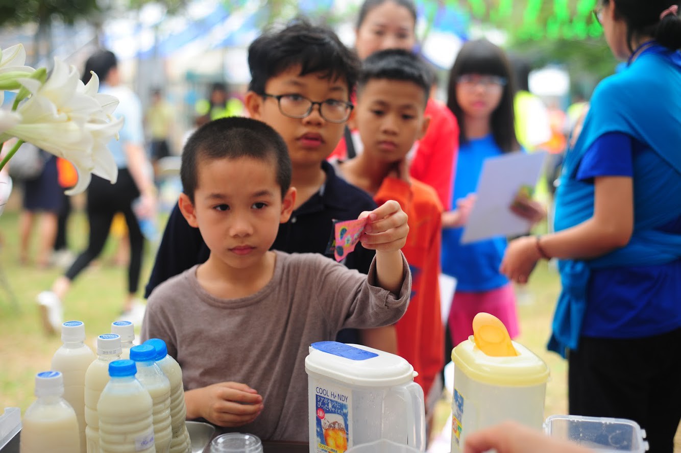 Khách hàng nhí chờ đến lượt mua hàng tại “Quán sống chậm”. Những bạn nhỏ này đã rất trật tự và kiên nhẫn, tạo cơ hội để các bạn của Trung tâm Hand in hand thực hành các thao tác được chính xác, không bị bối rối, áp lực.