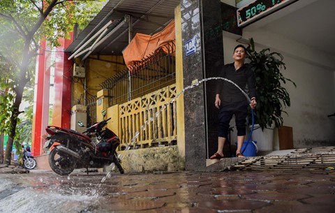 
Người dân xịt nước lên vỉa hè trước cửa nhà làm giảm không khí oi bức. Người đàn ông này nói việc xịt nước có thể giúp hạ từ 4 tới 5 độ C.
