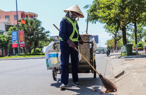 Nắng nóng khiến sinh hoạt của người dân bị đảo lộn. Trên các tuyến đường vắng bóng người qua lại lúc buổi trưa. Trong hình nữ công nhân lao công trùm kín người để để làm việc giữa trời nắng tại đường Hùng Vương, TP Tam Kỳ.