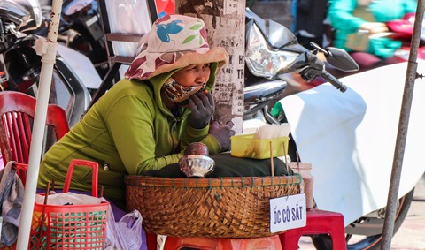 Bà Sắt bán ốc cho hay để tránh cái nắng bà phải dùng chiếc dù lớn để trắng nắng, tuy nhiên do hơi nóng từ mặt đường bốc lên nên phải mặc kín người.