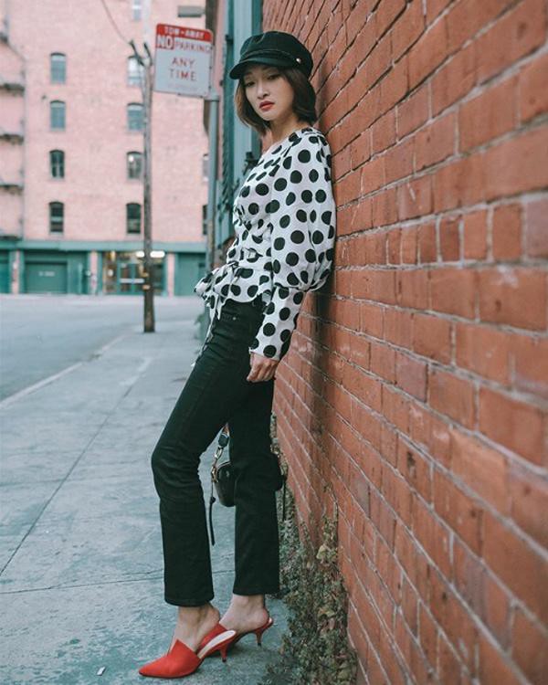 Áo blouse phủ họa tiết chấm bi diện chung với quần jeans đen là một gợi ý lên đồ khá hay ho dành cho các nàng ưa thích phong cách nổi bật.