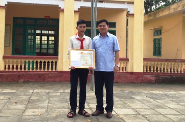 Ông Phạm Văn Đạt, Phó Chủ tịch UBND huyện Ngọc Lặc (Thanh Hóa) trao giấy khen và phần thưởng tới em Vũ Văn Hùng.