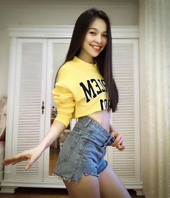 Hiền Thục luôn khéo léo khoe lợi thế cơ thể. Chiếc áo crop top vàng được cô mix với short jeans rách gấu.