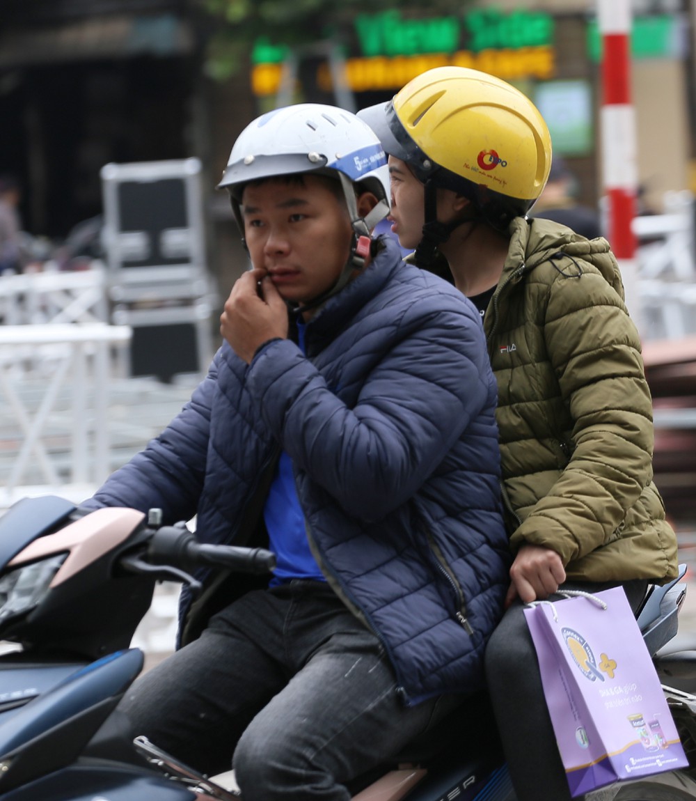 Đôi vợ chồng rủ nhau mặc áo ấm trong buổi sáng se lạnh.
