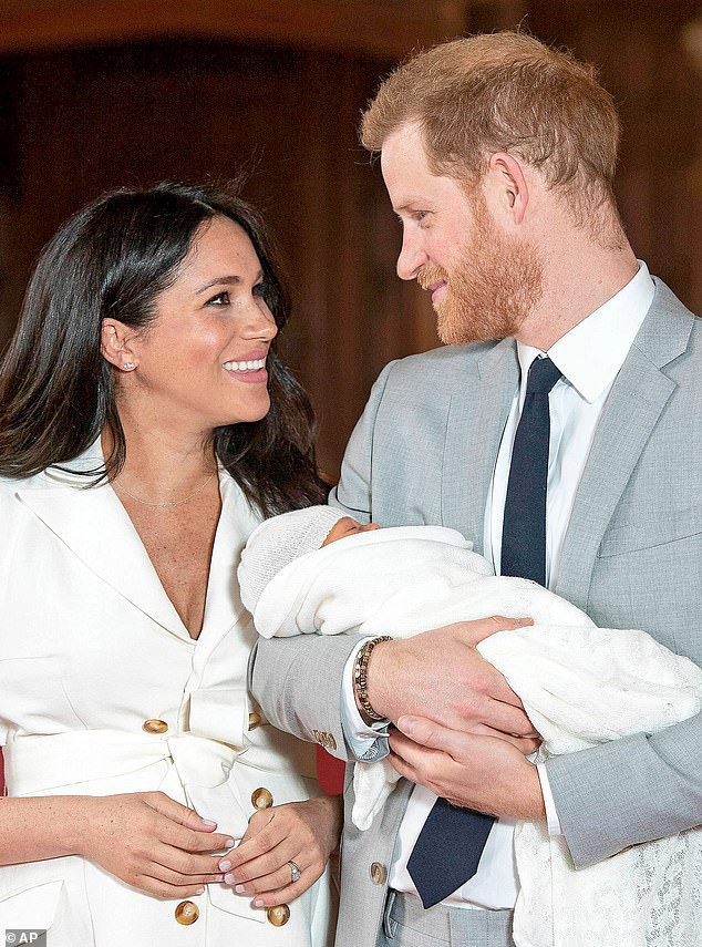 
Meghan Markle âu yếm bên chồng. Còn em bé mới sinh thì nằm ngủ ngoan trong vòng tay của bố, hoàng tử Harry.
