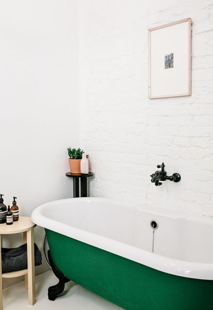 
Bồn tắm màu ngọc lục bảo với đôi chân màu đen là một điểm nhấn đầy màu sắc táo bạo trong phòng tắm trung tính.
