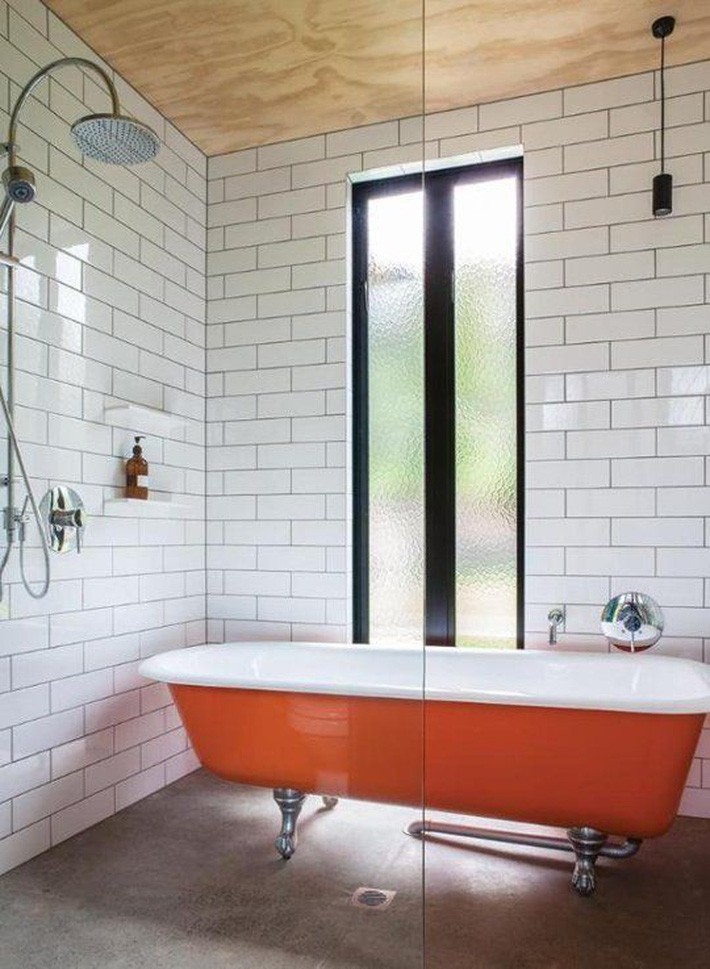 
Phòng tắm đơn sắc với bồn tắm Clawfoot màu cam đậm tạo thêm màu sắc và đem lại sự thích thú.
