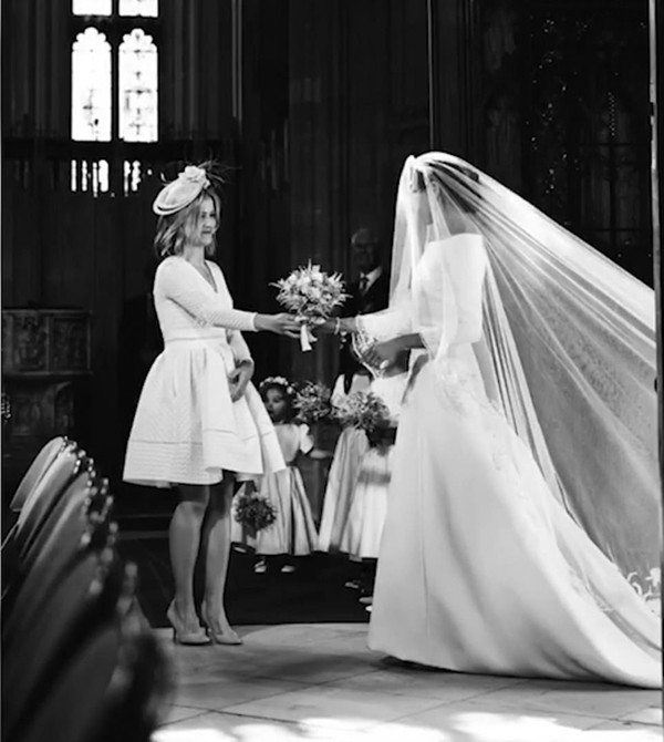 Clara Madden - trợ lý của Hoàng tử Harry - đưa hoa cưới cho Meghan bên trong nhà nguyện St. George, lâu đài Windsor hôm 19/5/2018. Ảnh cắt từ video.