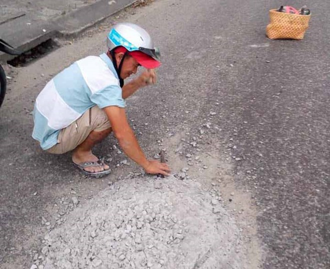 Sợ người đi đường sẽ gặp nạn với khối bê tông rơi vãi giữa đường, anh thợ đá đã nán lại hì hục đục phá