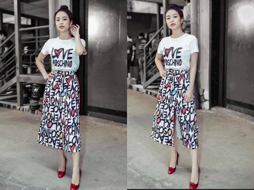 Áo phông mix cùng chân váy xẻ đùi của Moschino năng động, cá tính. Bông tai tua rua và giày cao gót đính nơ là bộ đôi phụ kiện điểm xuyết hoàn hảo cho set đồ.