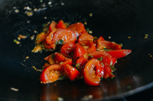 Khi cà chua đã chín mềm, trút lại trứng vào chảo rồi đảo sơ. Đậy nắp, nấu trong 2 phút rồi tắt bếp.