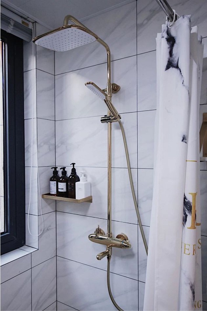 
Vòi tắm hoa sen có cùng chất liệu với viền gương và vòi nước giúp không gian thêm nổi bật hơn.
