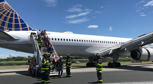 Lính cứu hỏa hỗ trợ hành khách sơ tán tại sân bay quốc tế Newark Liberty ở bang New Jersey chiều 15/6. Ảnh: Twitter.