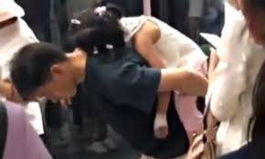 
Hình ảnh người bố gập lưng cho con gái ngủ.
