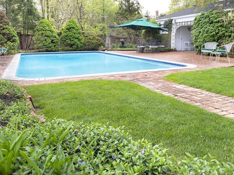 
Bể bơi ngoài trời rộng lớn được bao quanh bởi đường lát gạch và bãi cỏ xanh mướt.
