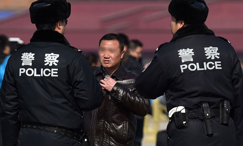 Cảnh sát Trung Quốc kiểm tra giấy tờ một người đàn ông ở Bắc Kinh. Ảnh: AFP.