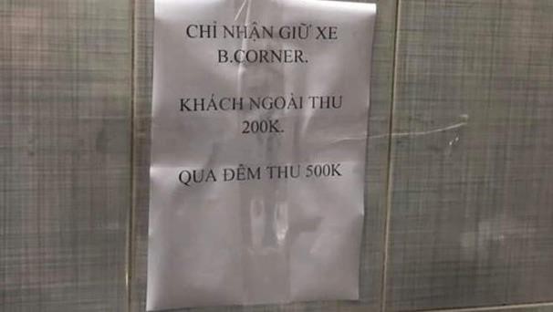 
Thông báo giữ xe giá 200.000 đồng với khách không mua hàng dán trong hầm cửa hàng B.Corner. Ảnh: Phuong Bui.
