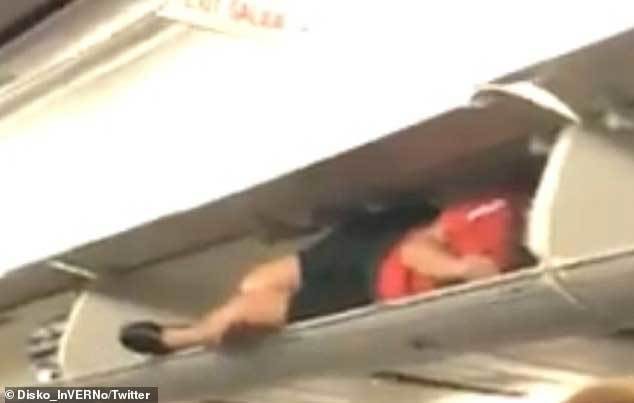 Đang ngồi trên máy bay, hành khách giật thót mình khi tiếp viên hàng không hành động lạ, chui vào hộc hành lý nằm - Ảnh 2.