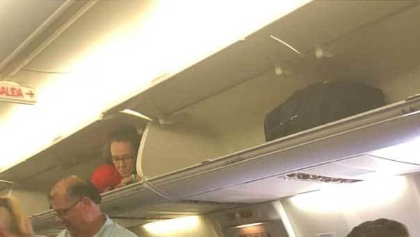 Đang ngồi trên máy bay, hành khách giật thót mình khi tiếp viên hàng không hành động lạ, chui vào hộc hành lý nằm - Ảnh 3.