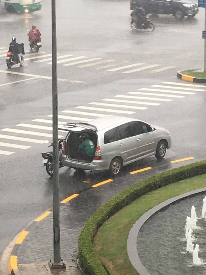 Ô tô 7 chỗ dừng bên góc đường, mở cửa để tài xế xe ôm kịp ngồi trú mưa khiến nhiều người cảm thấy ấm lòng - Ảnh 1. Ô tô 7 chỗ dừng bên góc đường, mở cửa để tài xế xe ôm kịp ngồi trú mưa khiến nhiều người cảm thấy ấm lòng - Ảnh 1.