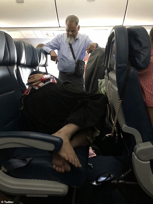 Bức hình người đàn ông đứng suốt 6 tiếng trên máy bay để nhường ghế cho vợ ngủ khiến cộng đồng mạng tranh cãi - Ảnh 1.