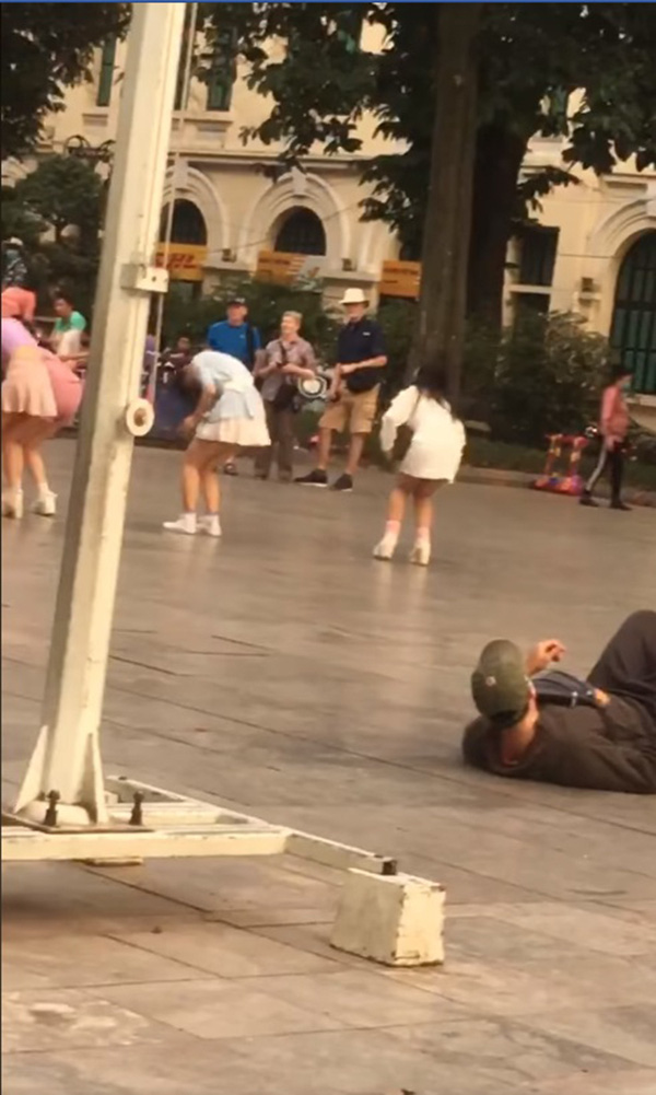 Người đàn ông nằm hẳn xuống đất quay video nhìn trộm nhóm nhảy nữ ở đường phố khiến dân mạng tranh cãi dữ dội - Ảnh 1.