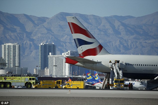 Firefighters stand by the plane to assess the damage the fire caused. A preliminary investigation suggested the left engine suffered a catastrophic failure 