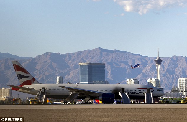 Another plane takes off the in the background as the charred fuselage of the British Airways aircract sits on the tarmac at McCarran Airport. Three runways were shut after the incident