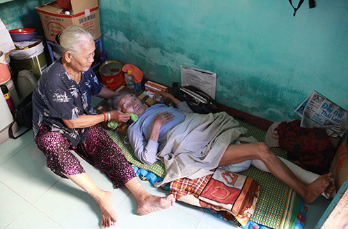 Bà Quế hàng ngày chăm sóc bà Anh trong căn nhà trọ chật hẹp. Ảnh: Nguyễn Đông.