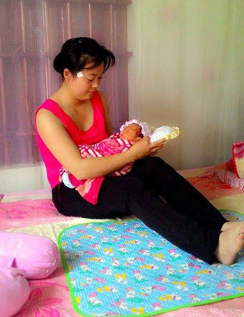 Chị Thu (vợ anh Phong) đang chăm sóc cháu bé trưa 16/10. Ảnh: Quỳnh Anh.
