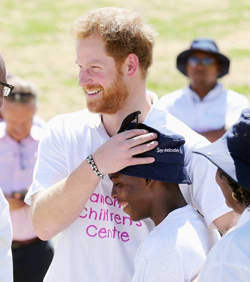 Harry thân mật ôm và xoa đầu một cậu bé mồ côi ở Lesotho.