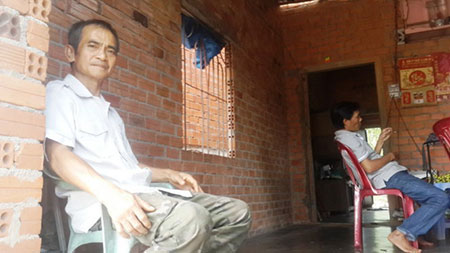 Ông Huỳnh Văn Nén với căn nhà chưa được tô tường của gia đình mình. Ông Nén nói ông muốn sửa sang lại ngôi nhà vì mưa bị tạt nước, còn trời nắng thì nóng hầm hập trên mái tôn phả xuống.