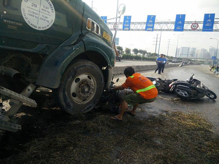 Dầu nhớt đổ l&ecirc;nh l&aacute;ng ra mặt đường khiến nhiều chiếc xe m&aacute;y bị trượt ng&atilde;. Người d&acirc;n tạm khắc phục bằng c&aacute;ch phủi vụn cỏ l&ecirc;n tr&ecirc;n - Ảnh: C&ocirc;ng Nguy&ecirc;n