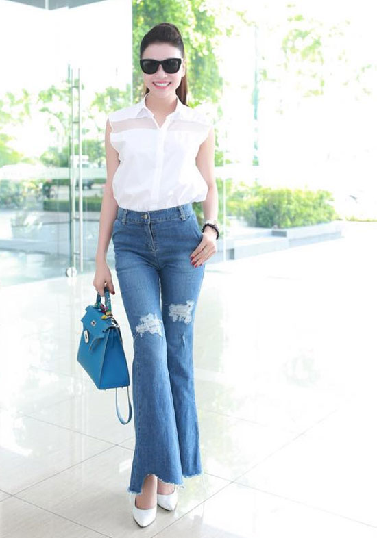 Áo sơ mi trắng giản dị được Trà Ngọc Hằng phối hợp cùng quần jeans rách ống loe rất phong cách.