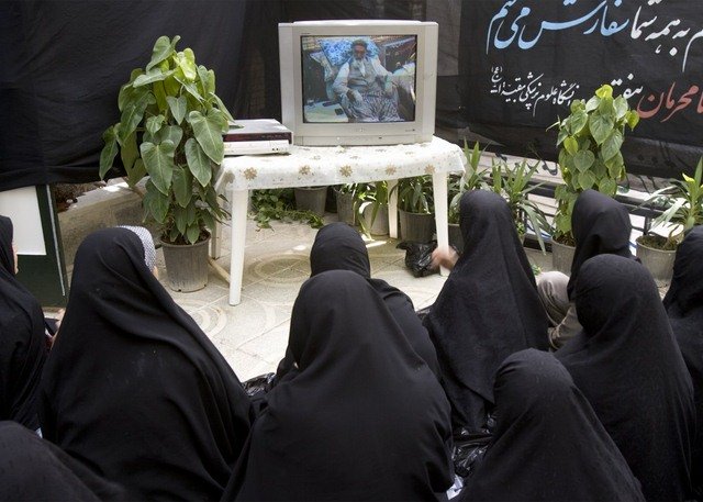Phụ nữ ở thủ đô Tehran (Iran) xem TV tưởng niệm cái chết của lãnh tụ tôn giáo Ayatollah Ruhollah Khomeini.
