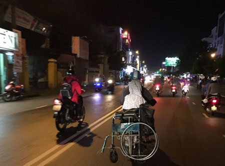 Cuối ngày người đàn ông vội vã dùng xe máy chở cháu bé về nơi tạm trú. Điều đáng nói, cháu gái có thể tự đi, đứng, chiếc xe lăn cũng được xếp lại phía sau.