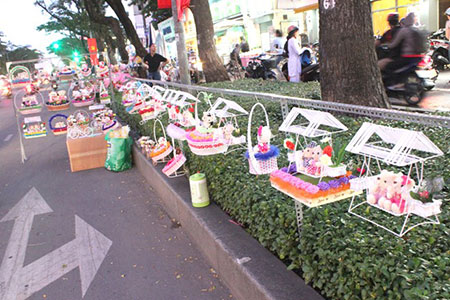 Người bán đầu tư thêm khung sắt để treo quà tặng dọc lề đường, thu hút sự chú ý của khách hàng. Ảnh: Zen Nguyễn