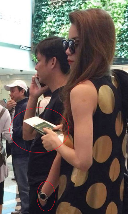 Cũng vẫn khuôn mặt và cánh tay đeo chiếc đồng hồ đắt tiền ấy đứng cạnh Hà Hồ, trên tay cô cầm 2 quyển hộ chiếu. Bức ảnh được một cư dân mạng chộp được khi Hà Hồ đang làm thủ tục tại sân bay Singapore.