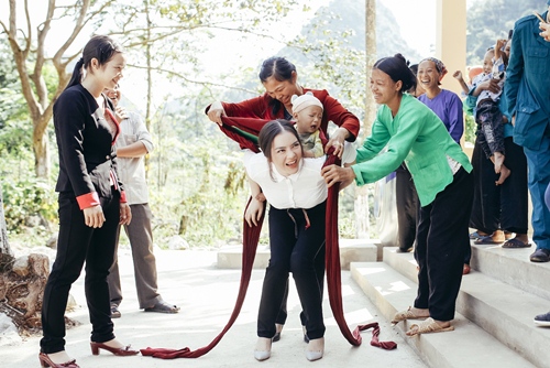 Nữ diễn viên Mùa hè lạnh trổ tài ẵm em bé trước sự chứng kiến của mọi người dân nơi đây.