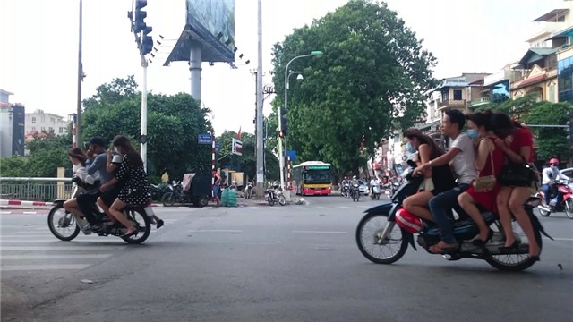  Mỗi xe thường chở 3 đến 4 cô gái, đều không đội mũ bảo hiểm. Hình ảnh được chụp tại ngã tư Nguyễn Chí Thanh - Láng. 