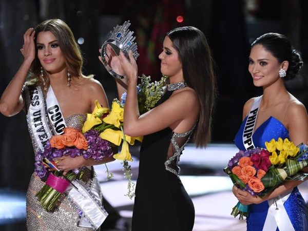 Hoa hậu Hoàn vũ 2014 Paulina Vega (giữa) lấy vương miện từ Hoa hậu Colombia 2015 Ariadna Gutierrez để trao cho Hoa hậu Philippines 2015, Pia Alonzo Wurtzbach sau nhầm lẫn của MC Steve Harvey - Ảnh: AFP