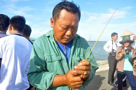 Thuyền vi&ecirc;n Nguyễn Đức Kỳ (51 tuổi, qu&ecirc; Đồng Th&aacute;p) thắp n&eacute;n hương viếng những đồng nghiệp xấu số - Ảnh: Đ.Thanh