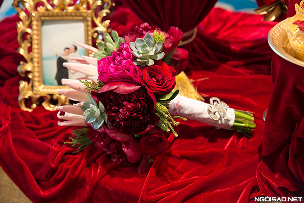 Hoa của cô dâu được kết từ những bông mẫu đơn đỏ rực, kết hợp cùng hoa hồng, hoa sen đá.
