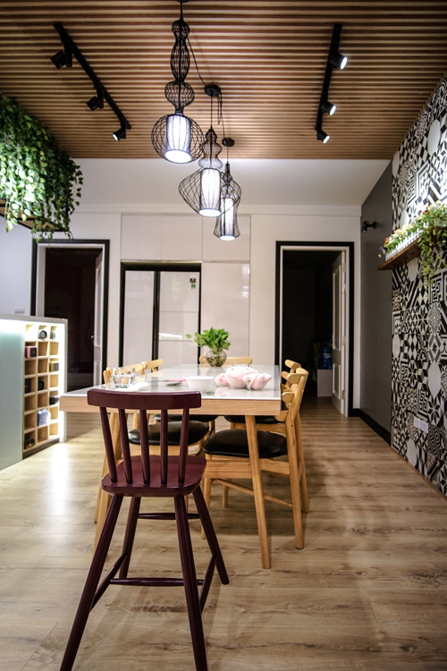 Mảng tường gạch bông kết hợp với hệ trần nan gỗ được lựa chọn làm phương án trang trí ấn tượng cho khu vực bàn ăn và bếp. Đây cũng được xem là góc thú vị nhất của căn hộ, là nơi quây quần của cả gia đình sau một ngày làm việc.