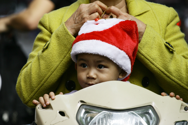 
Vẻ mặt ngộ nghĩnh, đáng yêu của một bé trai khi đội mũ ông già Noel.
