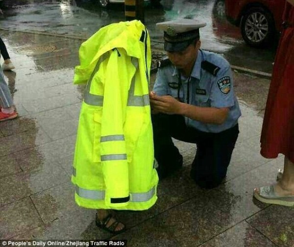 
Mặc cho bản thân bị ướt như chuột lội, anh cảnh sát giao thông này vẫn sẵn sàng cởi áo bảo hộ để che chắn cho một em bé đi lạc.
